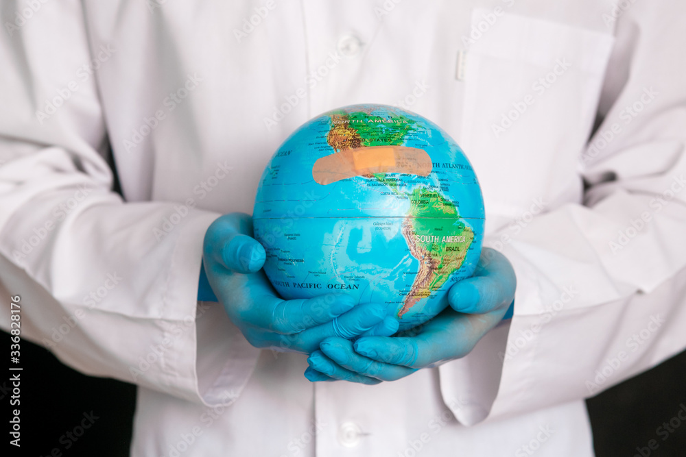 Cropped image of male doctor man in medical gown sterile face mask gloves isolated on blue background. Epidemic pandemic coronavirus 2010-ncov sars covid-19 flu virus concept. Hold Earth world globe Cropped image of male doctor man in medical gown sterile face mask gloves isolated on blue background. Epidemic pandemic coronavirus 2010-ncov sars covid-19 flu virus concept. Hold Earth world globe