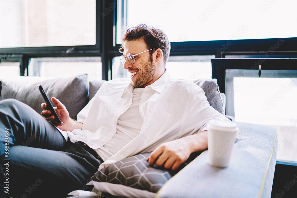 Smiling businessman surfing on cellphone