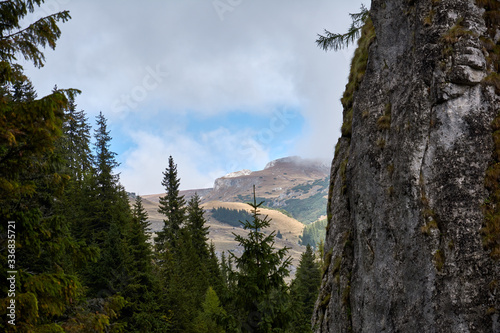 View of the rocks near the entrance to the Lalomita Cavee in the Bucegi mountains, Romania. Autumn mountain landscape. photo