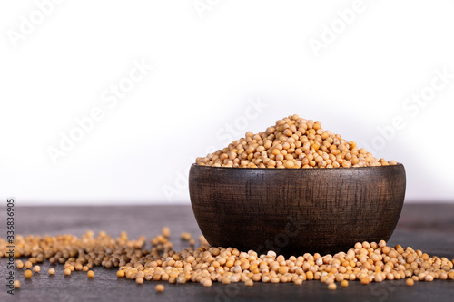 Sinapis alba - Organic yellow mustard seeds in the wooden bowl