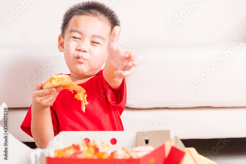 Little Child eating Delivery Pizza and show good finger thumb