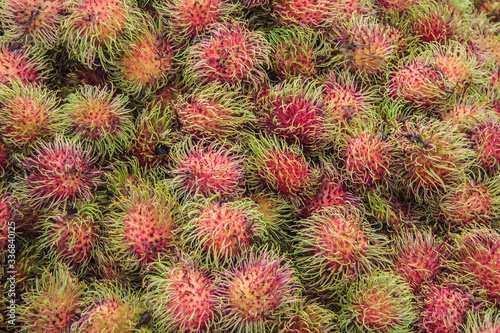Suzhou China - May 3, 2010: closeup of heap of Rambutan green spiked red fruits.