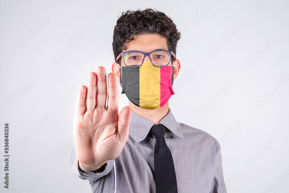 Man wearing mask with Belgium flag asking to keep a social distance. Covid-19, SARS-CoV-2. Concept of social distance. Man wearing mask with Belgium flag asking to keep a social distance. Covid-19, SARS-CoV-2. Concept of social distance.