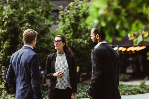 Female and male entrepreneurs discussing business strategy while standing outdoors