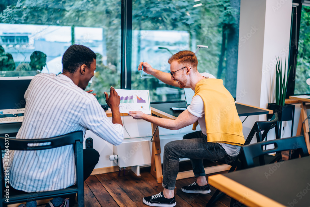 Obraz premium Diverse coworkers laughing at charts