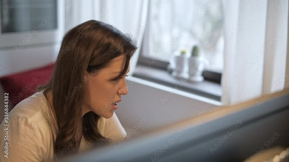 A young, beautiful woman is looking at a computer monitor. Remote work. Online teaching. The teacher shows the exercise. The neuropsychologist works remotely. Home furnishings. A young, beautiful woman is looking at a computer monitor. Remote work. Online teaching. The teacher shows the exercise. The neuropsychologist works remotely. Home furnishings.