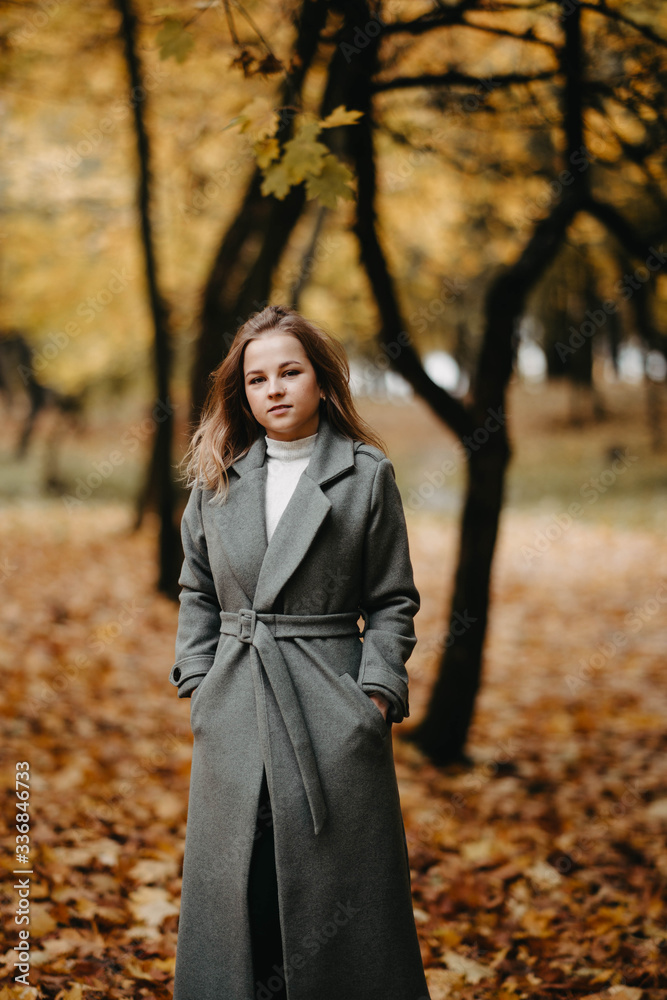 young woman in autumn forest in a gray coat. young woman in autumn forest in a gray coat.