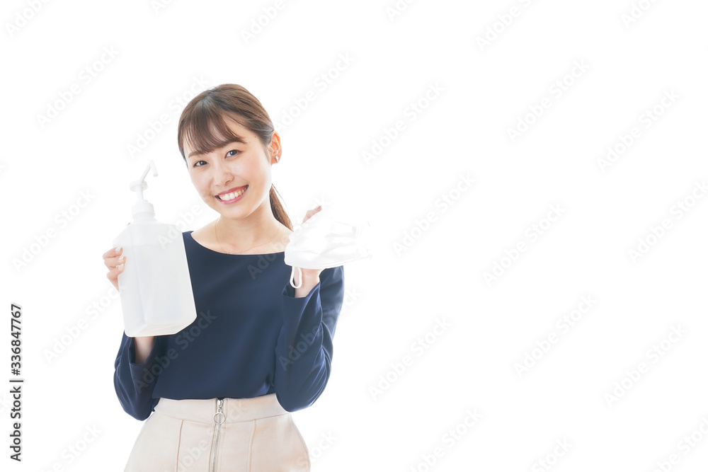 マスクをアルコール消毒する若い女性