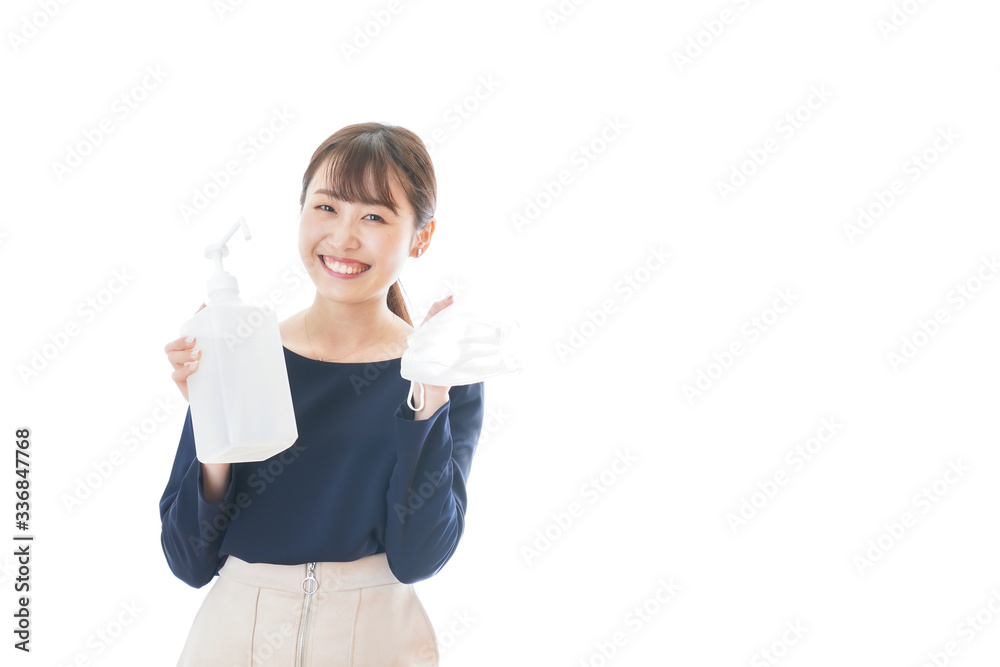 Obraz premium マスクをアルコール消毒する若い女性
