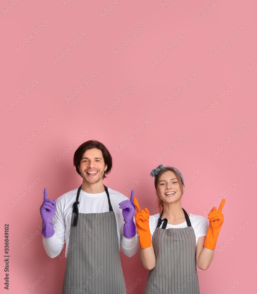 Cleaning Service Ad. Happy Couple In Protective Rubber Gloves Pointing Upwards