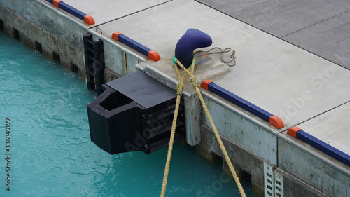 berth in the passenger port. Mooring points of the ship are fixed in the port. bright blue bollard with ship ropes.
