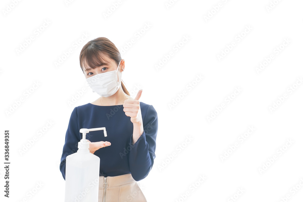 OKサインをしながらアルコール消毒をする若い女性 OKサインをしながらアルコール消毒をする若い女性