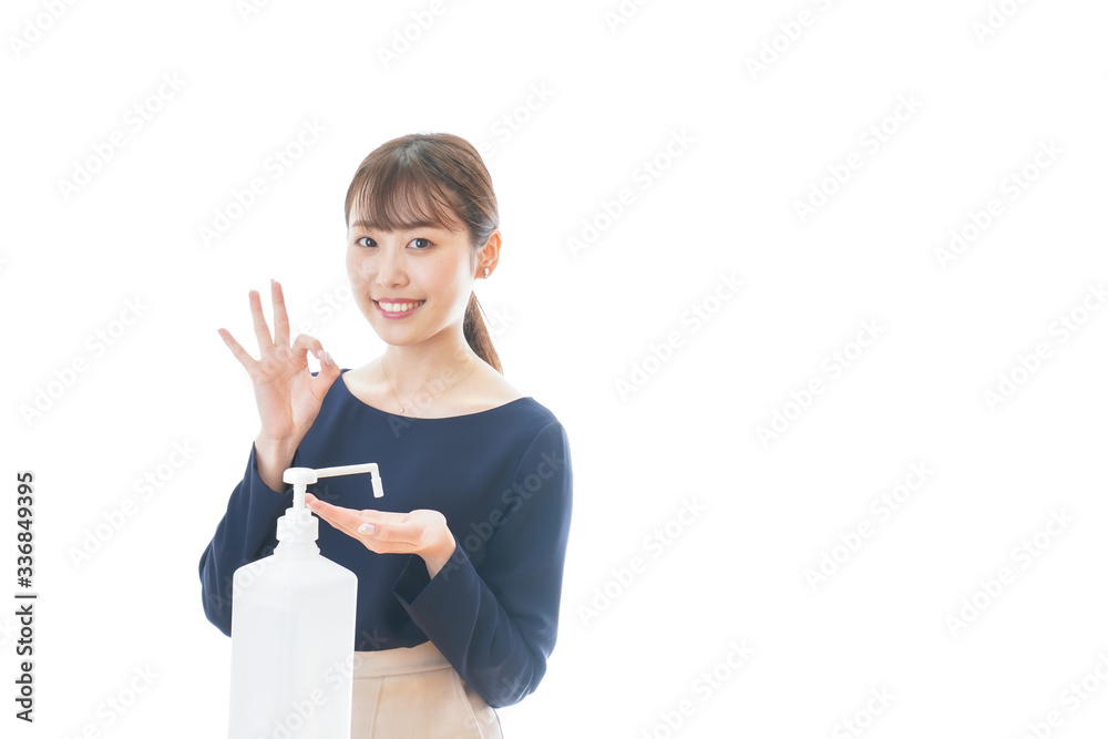 OKサインをしながらアルコール消毒をする若い女性