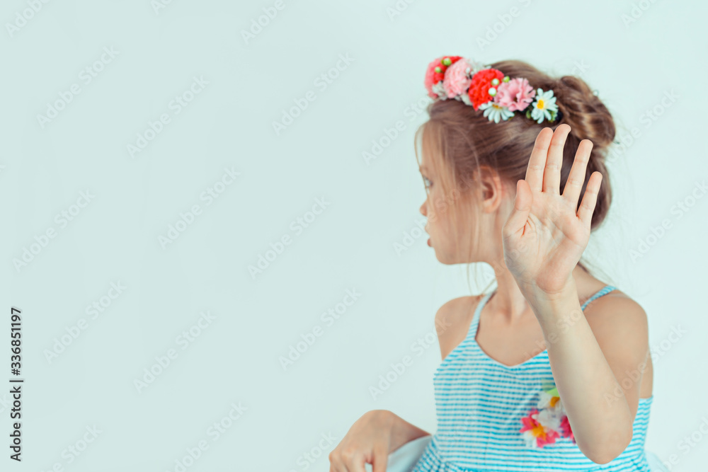 No. Stop! Closeup girl showing hand signaling to stop violence and pain looking side wards down with sad face. Angry serious kid showing her denial talk to hand gesture with palm outward on white