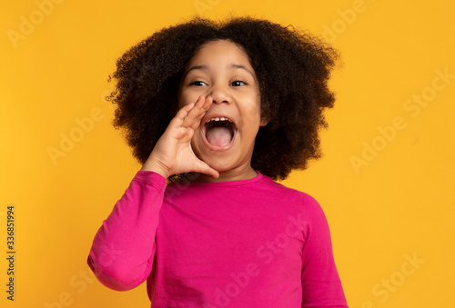 Funny little african american girl emotionally screaming, making announcement photo