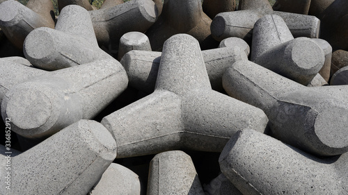 Texture breakwater consisting of gray concrete tetrapods, breakwater texture background. Shoreline strengthening, defense