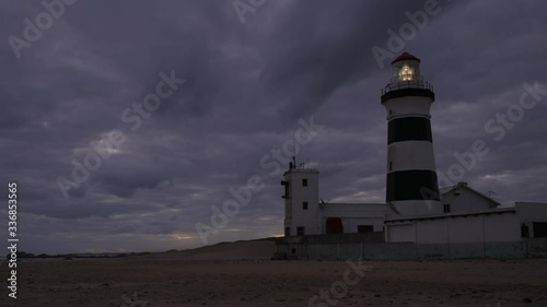 Cape Recife Lighthouse, sunset to darkness as clouds move. Light starts up, rotates. Time lapse 