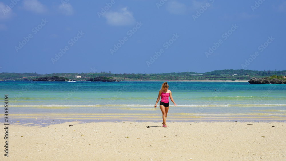beautiful girl model in pink clothes on the ocean shore. blonde walks on a clean beach by the sea. tropical island vacation beautiful girl model in pink clothes on the ocean shore. blonde walks on a clean beach by the sea. tropical island vacation