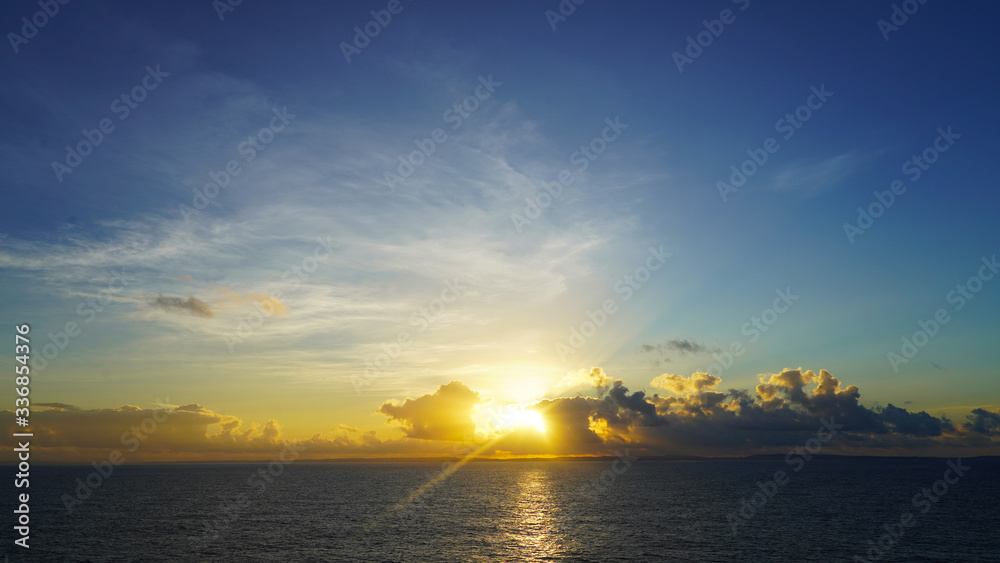 Golden sunset. blue sky with white clouds and bright sunset sun. dramatic summer sky background