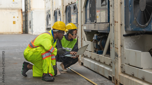 industrail background of containers yard and cargo maintenance team of african american technical worker and inspector making maintenance service for cooling unit of refrigerator containers photo