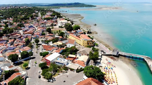 Beautiful aerial from Praia do Forte beach with turquoise water and cute town. Incredible view of Itaparica Island, Bahia, Brazil. Drone moving up. photo