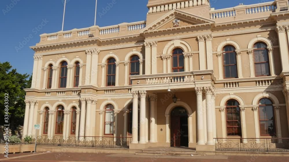 Tilt up to reveal beautiful facade and clock tower of historic Port Elizabeth City Hall on sunny day Tilt up to reveal beautiful facade and clock tower of historic Port Elizabeth City Hall on sunny day