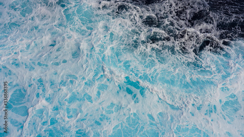 Texture of foamy dark blue sea, white streaks on the water surface