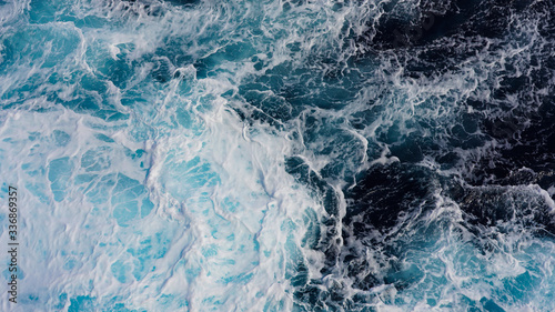 Top view on blue ocean waves. Blue water background