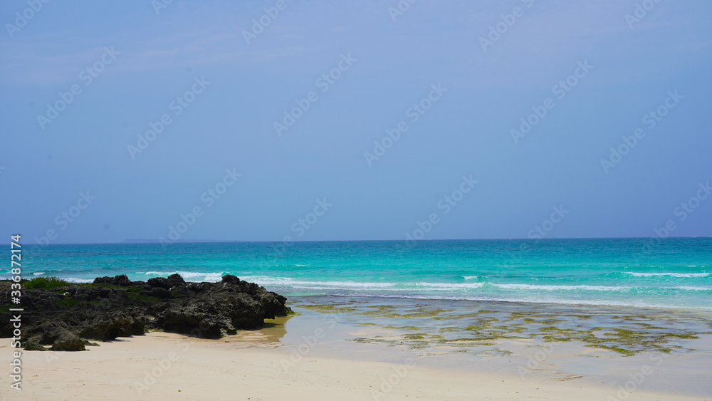Paradise sea landscape, snow-white beach against the background of bright unusual colors of ocean water white light waves.Sea coast against a clear blue sky on the islands of Okinawa,Miyakojima, Japan