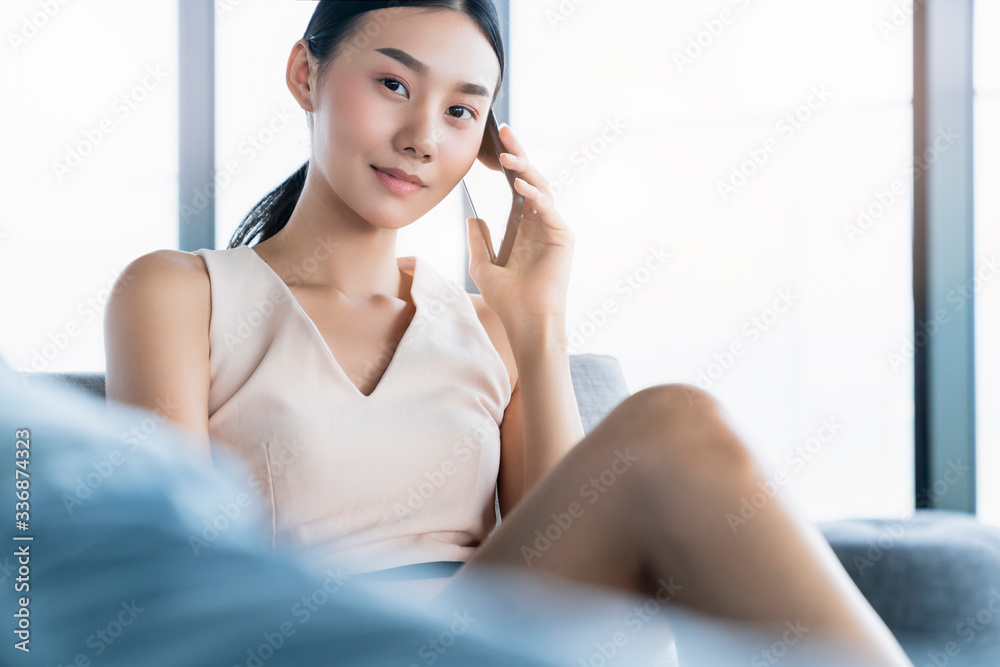 smart attractive beautiful asian female working form home hand use smartphone sit in sosfa couch home interior background relax and casual working expression feeling smart attractive beautiful asian female working form home hand use smartphone sit in sosfa couch home interior background relax and casual working expression feeling