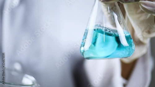 laboratory, scientist pour color liquid solution to test Beaker for analyzes extract the DNA and molecules.Scientist fills and shakes large liquid in glass beaker flask at chemical laboratory.