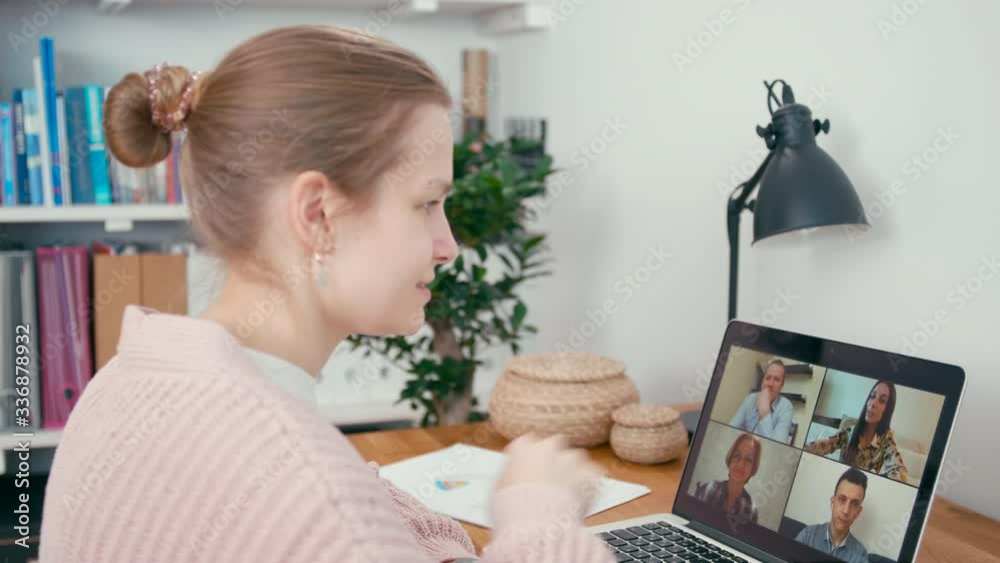 Woman Greets Work Team in Online Group Video Call Conference using Laptop in Home Office. Family or Collegues Talk via Internet. Self-isolation at COVID-19 Pandemic. 4K Close up Medium Orbit Shot Woman Greets Work Team in Online Group Video Call Conference using Laptop in Home Office. Family or Collegues Talk via Internet. Self-isolation at COVID-19 Pandemic. 4K Close up Medium Orbit Shot