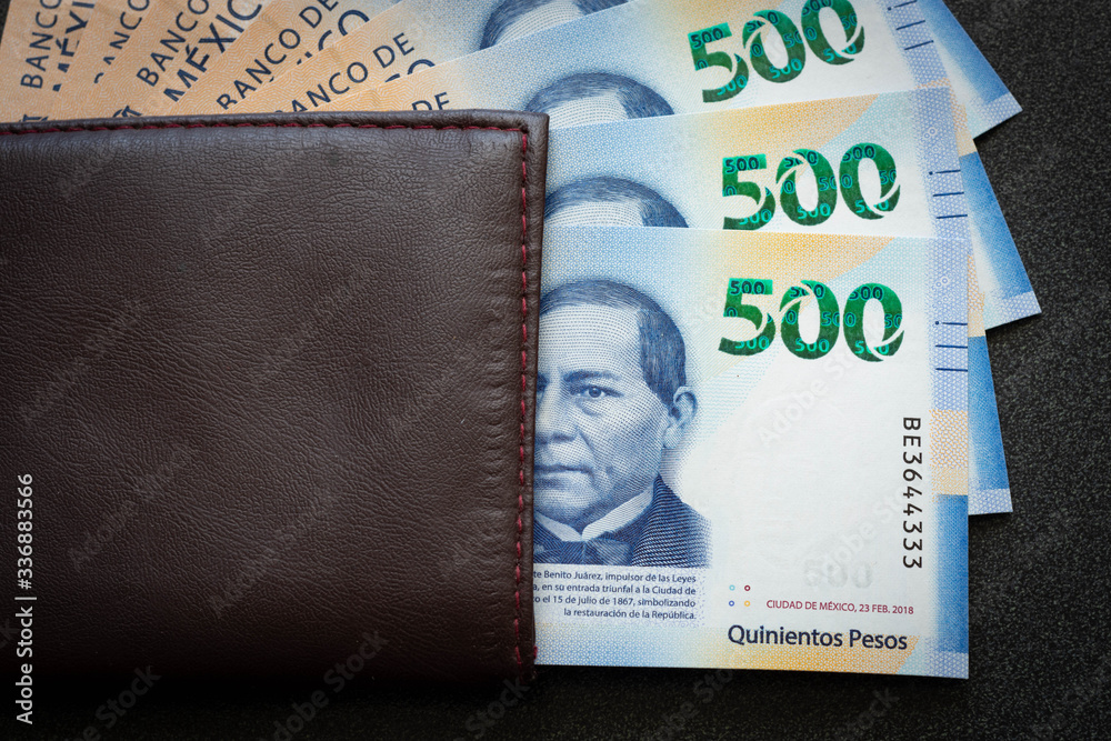 Obraz premium Mexican 500 pesos pile of blue bucks inside a wallet watching dollar