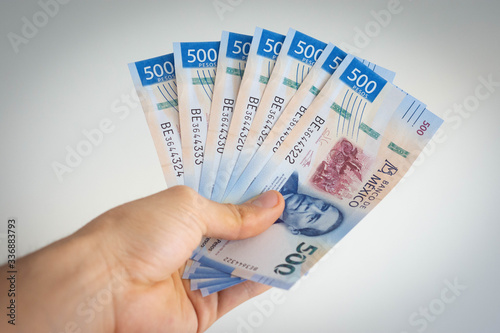 Hand holding various mexican pesos of 500 photo