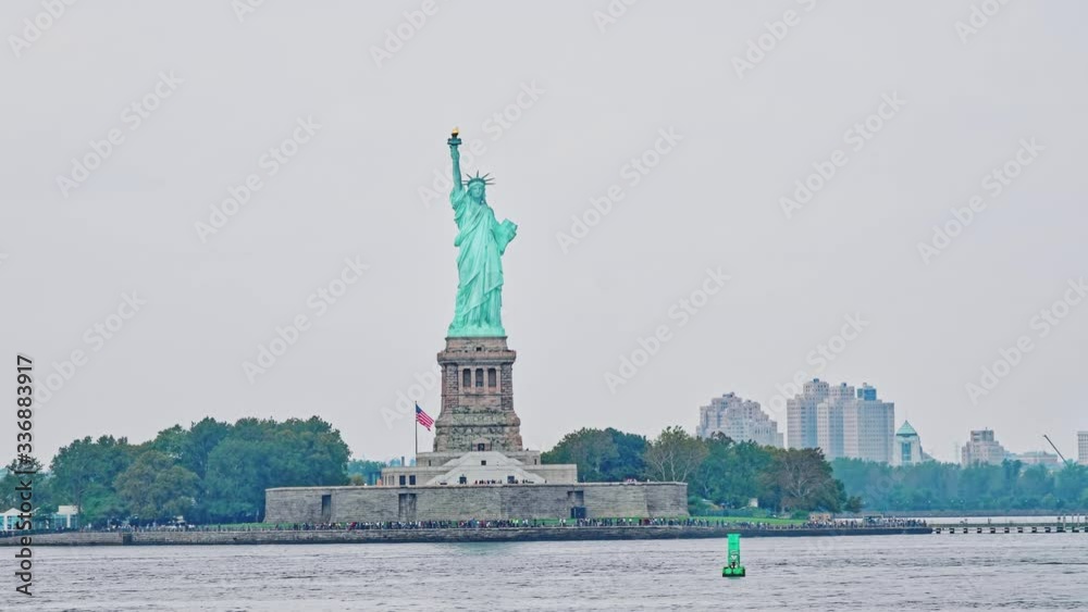 Statue of Liberty on Liberty Island during the gloomy weather in New York. Police department speedboat passing by. Statue of Liberty on Liberty Island during the gloomy weather in New York. Police department speedboat passing by.