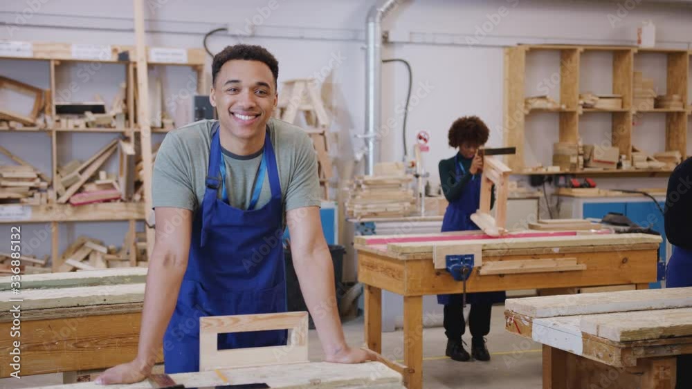 Portrait of male student in carpentry workshop studying for apprenticeship at college - shot in slow motion Portrait of male student in carpentry workshop studying for apprenticeship at college - shot in slow motion