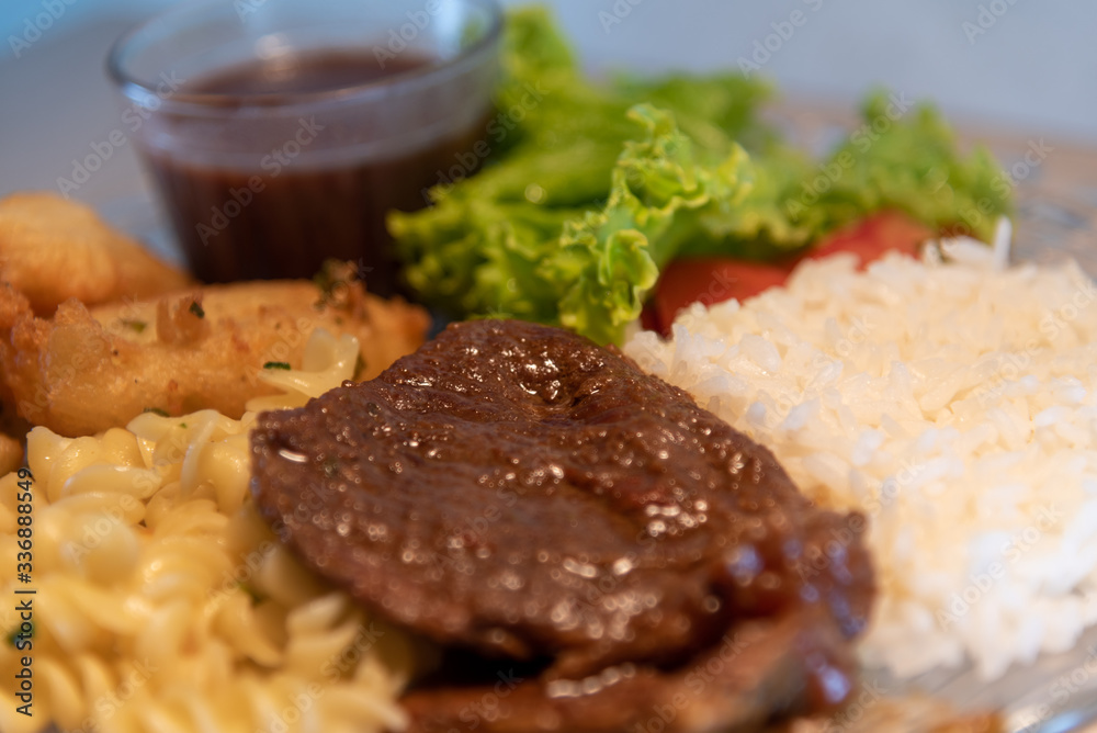 Popular dish of Brazilian food with rice beans pasta with meat and salads