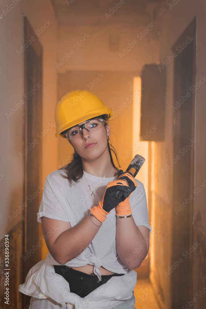 Young tough woman working as a construction worker wearing protective ...