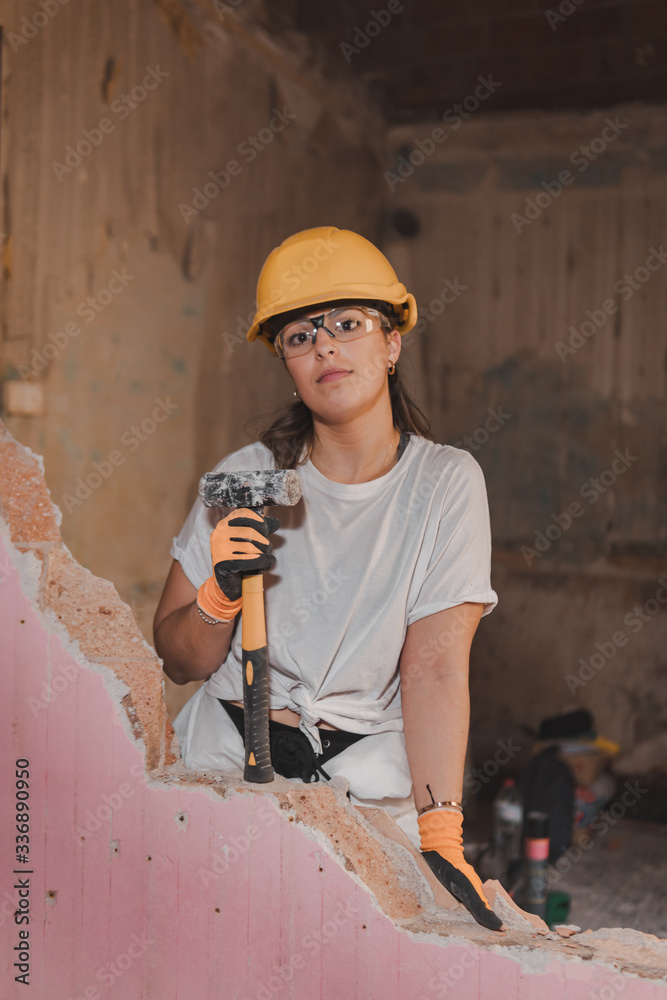 Young tough woman working as a construction worker wearing protective ...