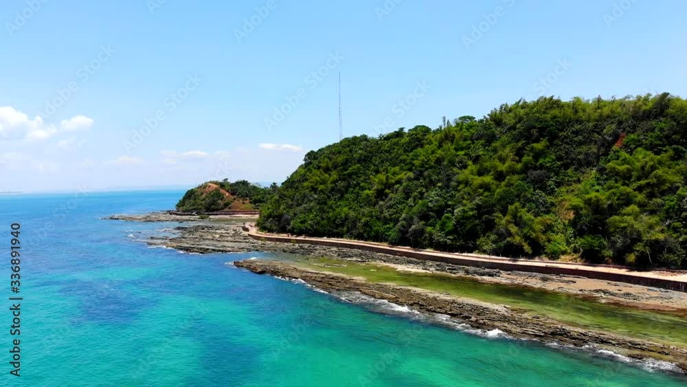 Beautiful aerial shot of Ilha Dos Frades Island, Bahia, Brazil. Tourists walking on shore between the beach and incredible forest. Drone moving forwards.