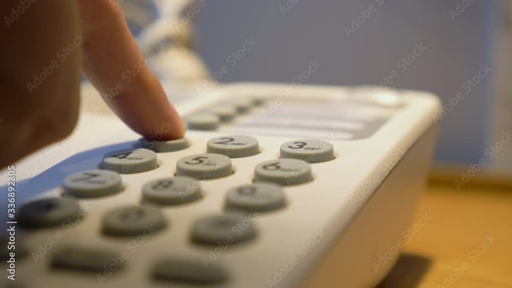Hotel phone services concept.Closeup of hotel guests Pick up the phone holding and dialing phone number to room services.Vintage old telephone is a keypad. Hotel phone services concept.Closeup of hotel guests Pick up the phone holding and dialing phone number to room services.Vintage old telephone is a keypad.