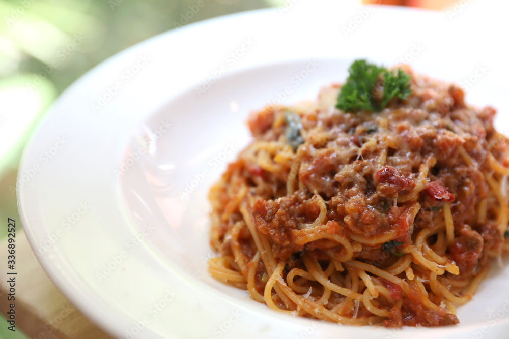 spaghetti Bolognese with minced beef and tomato sauce garnished with parmesan cheese and basil , Italian food