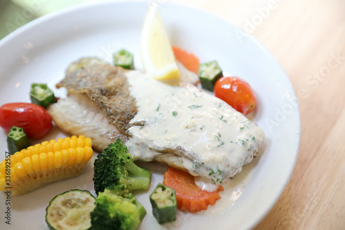 Sea bass fillet   baked sea bass with lemon sauce on wood background