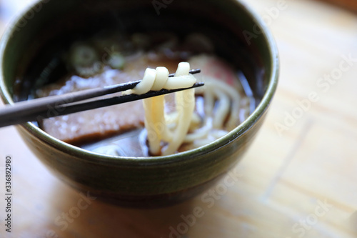 kitsune udon noodles with fish ball and tofu on wood background japanese food