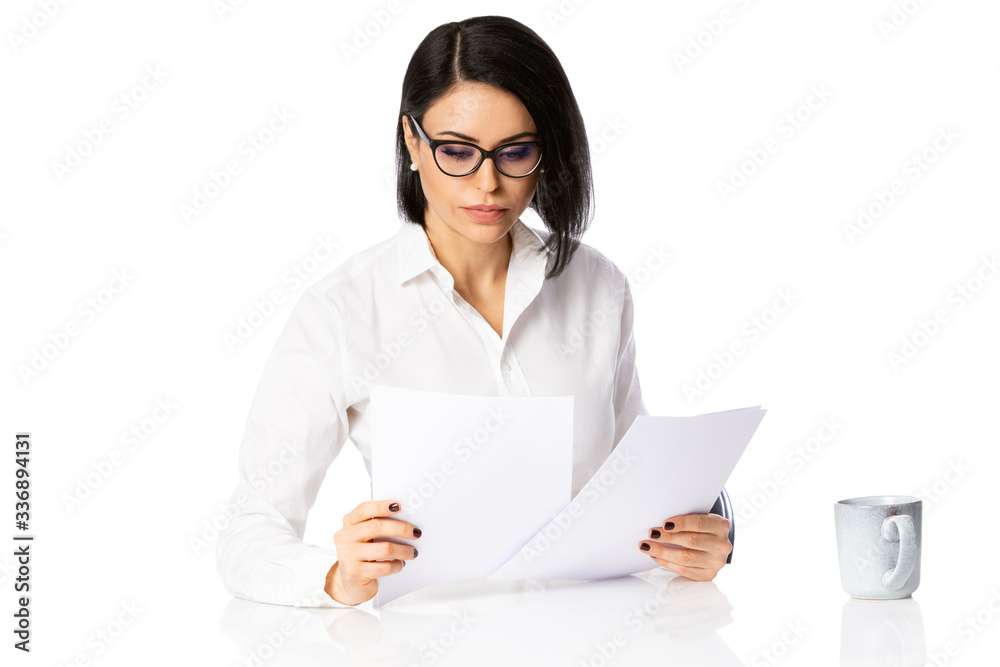 Pensive young business woman in glasses and white shirt with paper documents. Achievement business career concept. Isolated over white background Pensive young business woman in glasses and white shirt with paper documents. Achievement business career concept. Isolated over white background