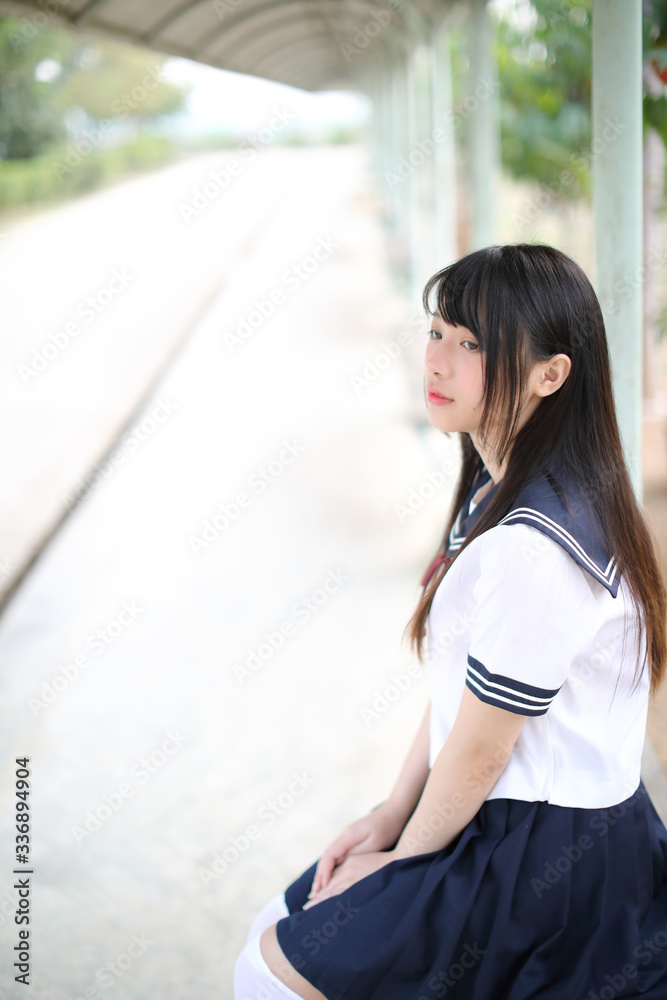 Asian school girl sitting with outdoor background