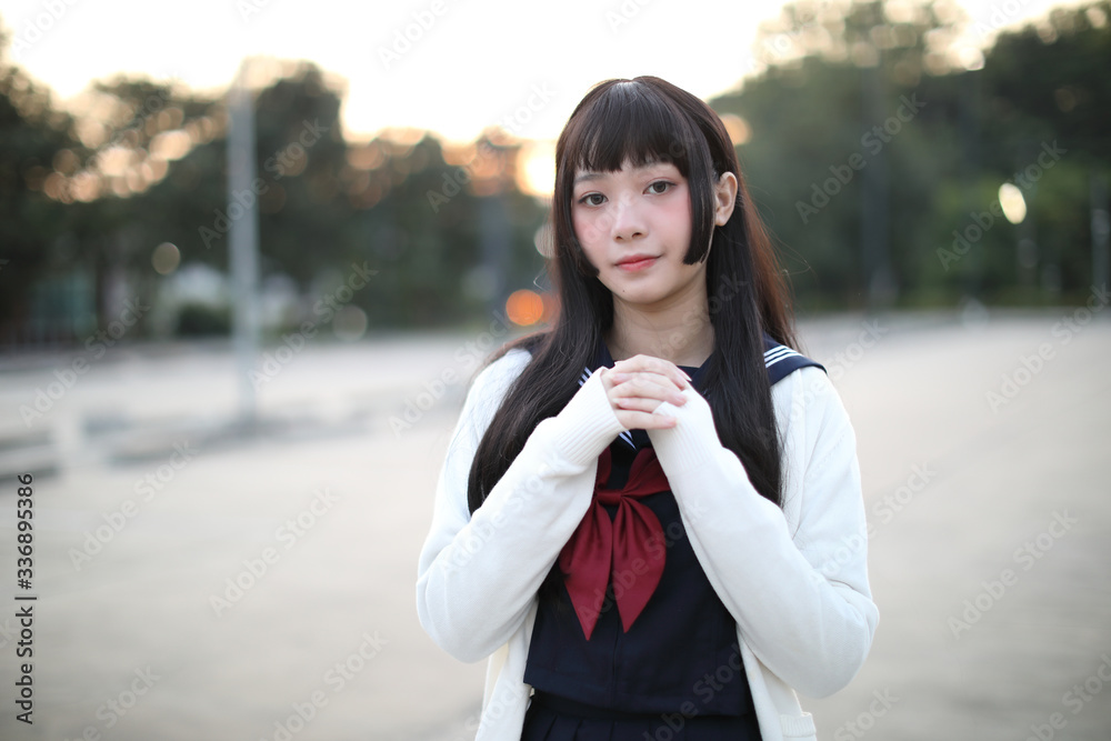 Asian school girl walking in urban city with green darden Asian school girl walking in urban city with green darden