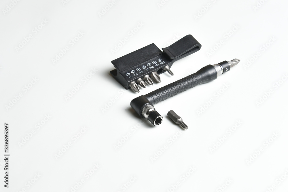 Angle L-shaped screwdriver with bit set and belt clip isolated on white background. Close up Angle L-shaped screwdriver with bit set and belt clip isolated on white background. Close up
