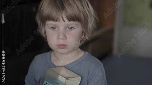 A small boy is looking at something intently.  The little boy looks intently into the distance