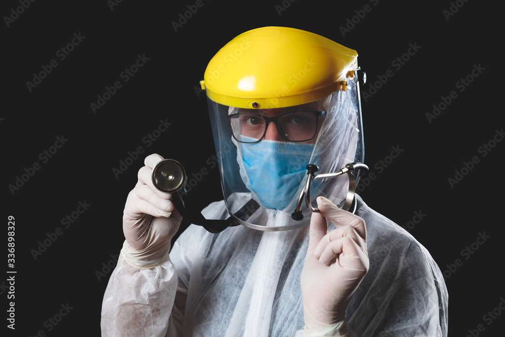 Medical doctor, nurse, surgeon, psychologist working with protective mask, glasses and gloves helping people in the days of panic, pandemic - studio shot on black background. Medical doctor, nurse, surgeon, psychologist working with protective mask, glasses and gloves helping people in the days of panic, pandemic - studio shot on black background.